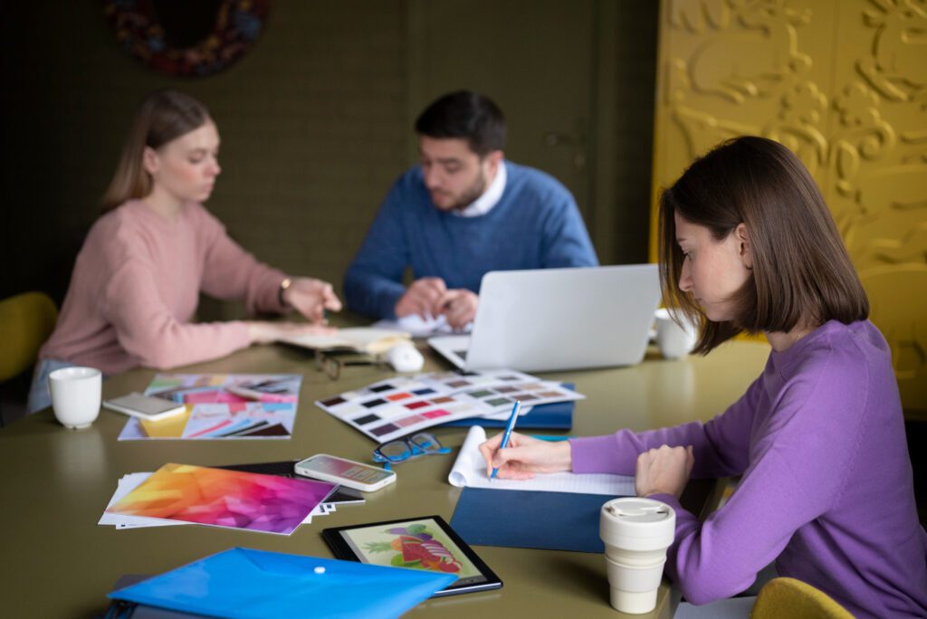 Branding y marketing digital: cómo combinarlos para potenciar tu marca 3 Personas de tiro medio trabajando en el escritorio